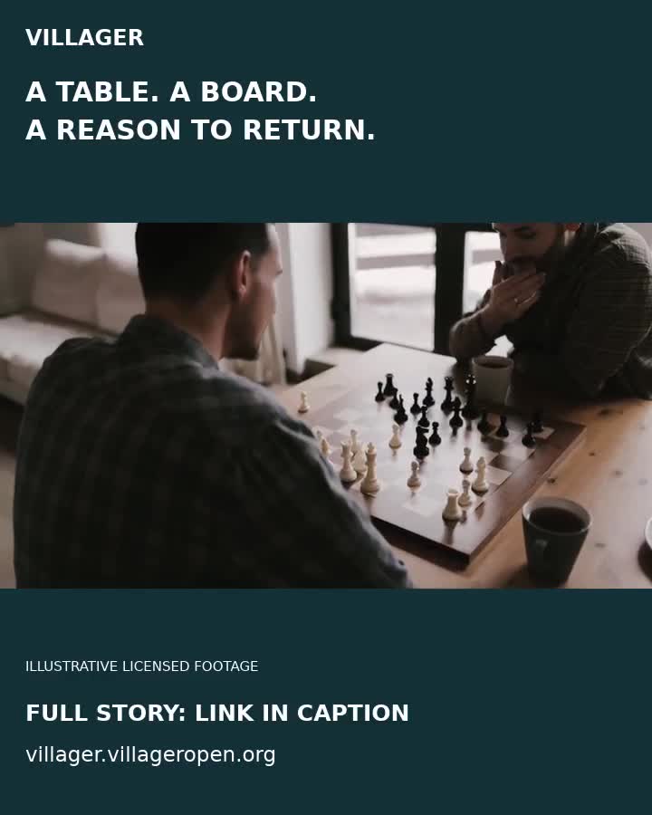 Two men deeply focused on a strategic chess game indoors.